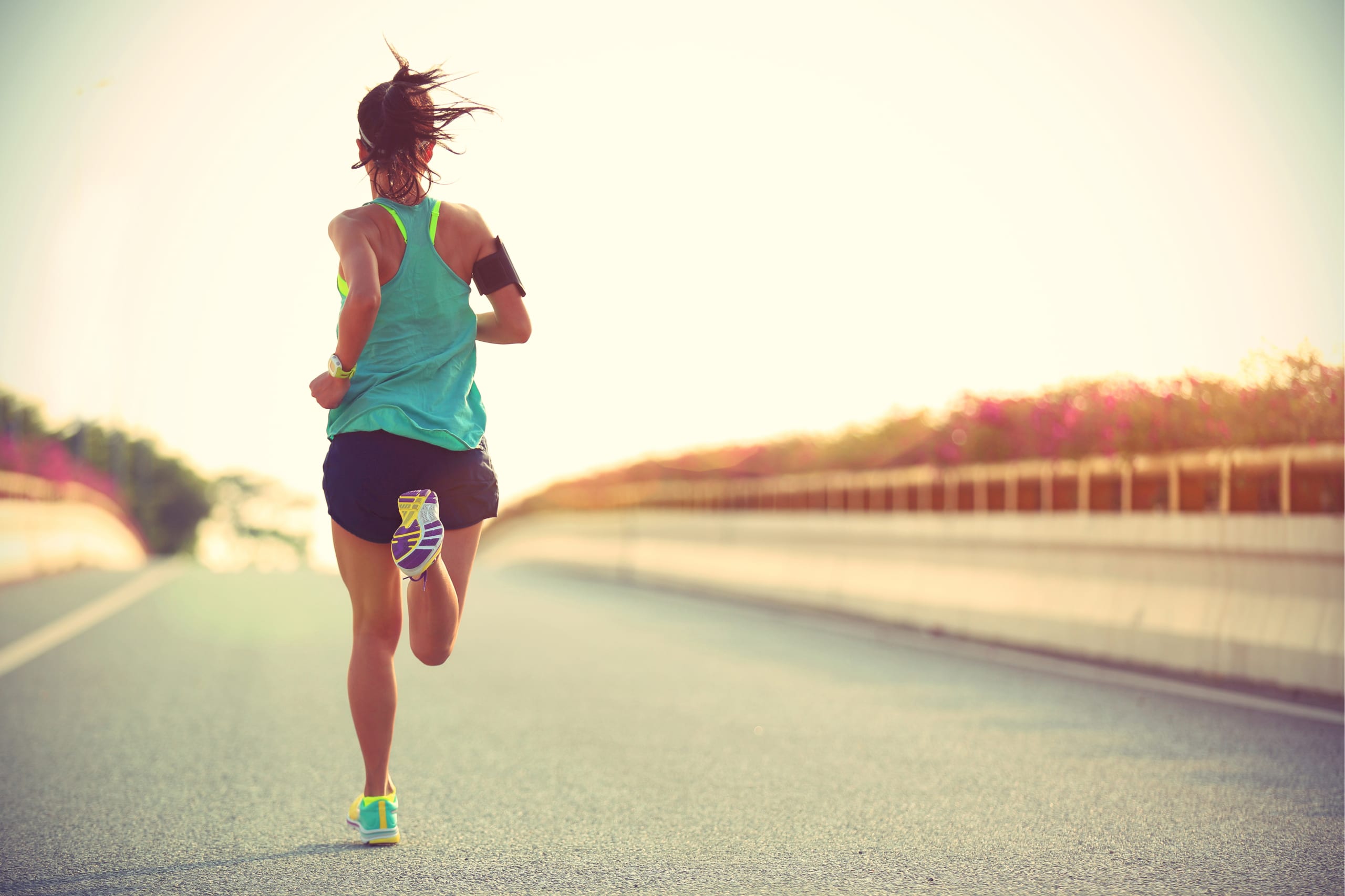 fitness must-haves to pack in your carry-on: woman running in shorts and sneakers